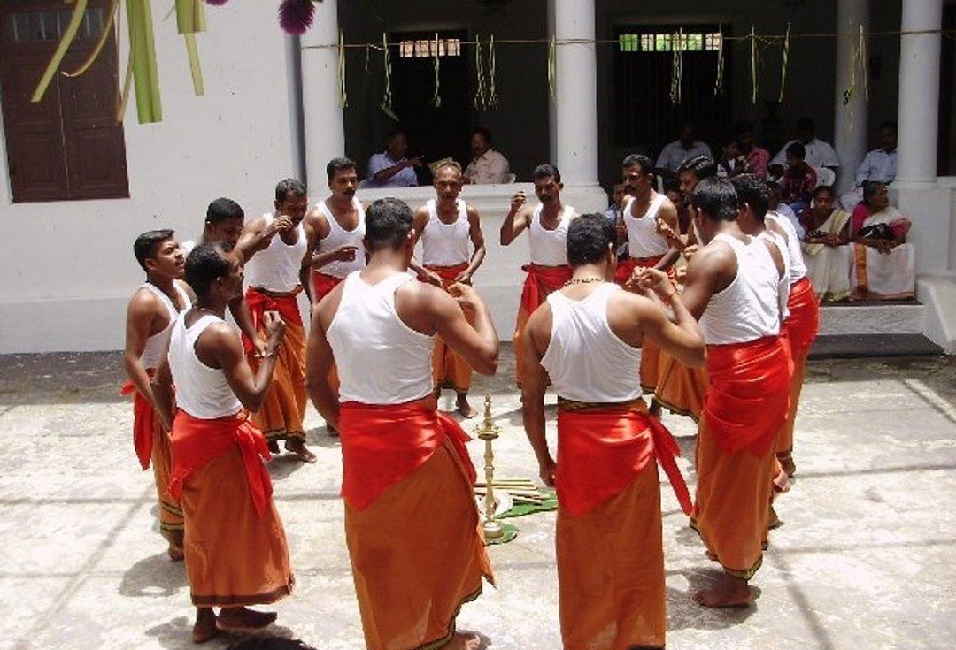 of the Mala Araya (Malayarayan) community, performing a traditional circular folk dance around a lighted brass lamp (nilavilakku).