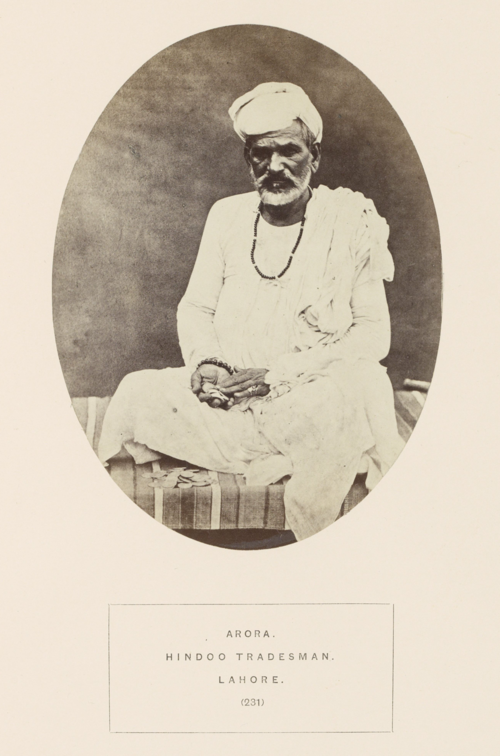 Portrait of an unidentified Arora Storekeeper from Lahore with coins in hand and in front of him, ca.1862–72