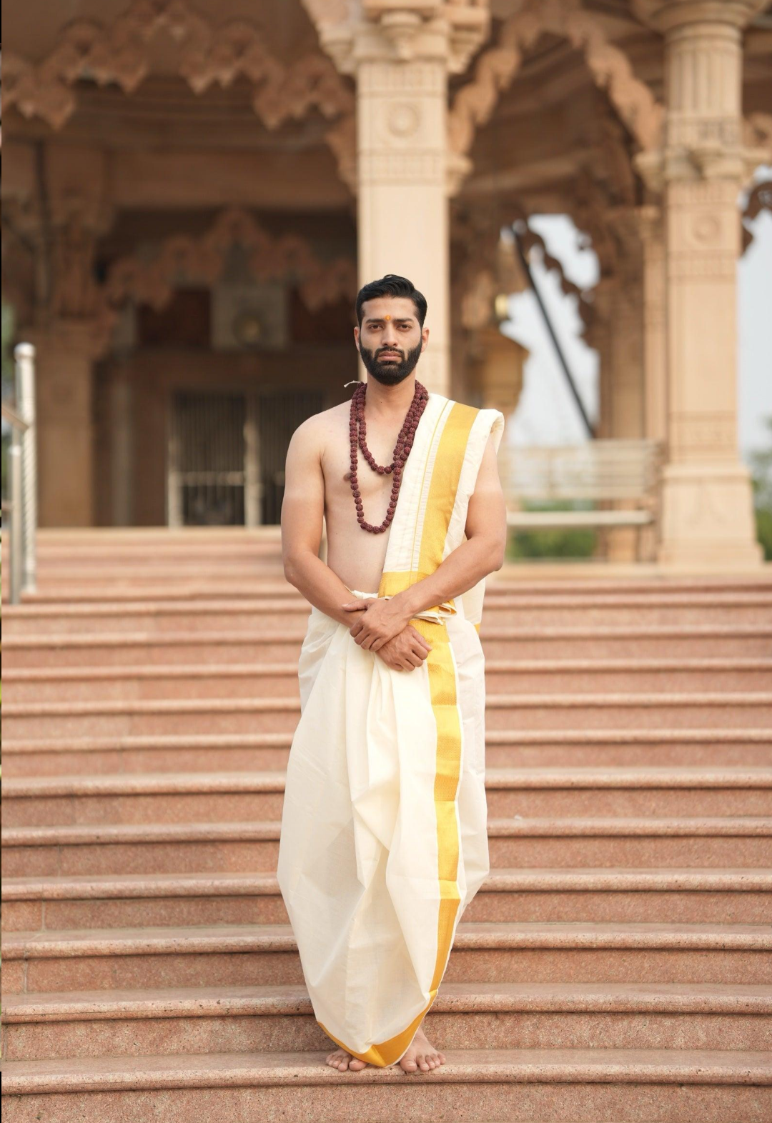 Traditional Kerala dress, including the white mundu and angavastram for men and the cream-and-gold mundum neriyathum or kasavu saree for women.