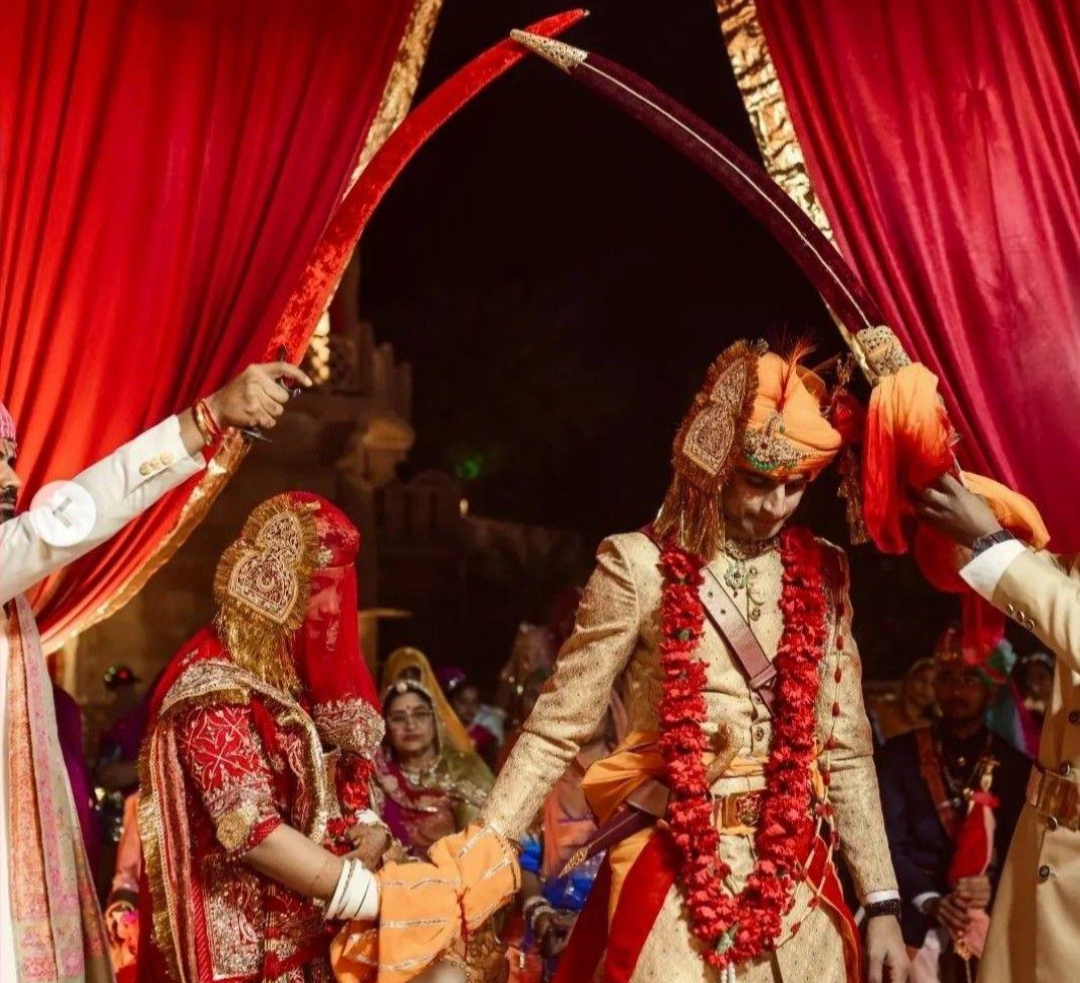 Traditional Rajput wedding attire, including the groom's safa and sword and the women's Rajputi poshak with ghaghra, odhni and traditional jewellery.